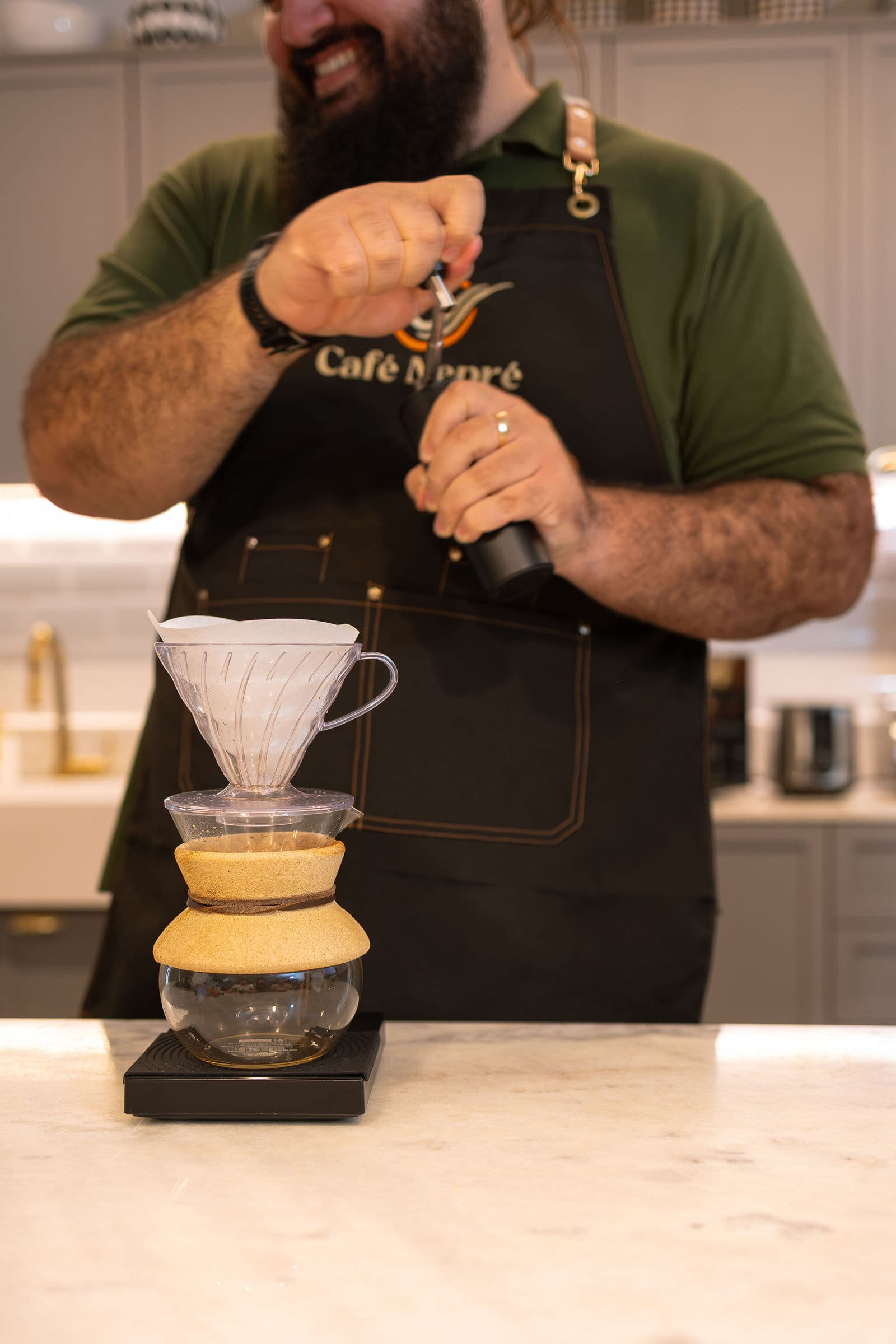 Barista do Café Nepré moendo café na hora sobre um V60 apoiado na balança